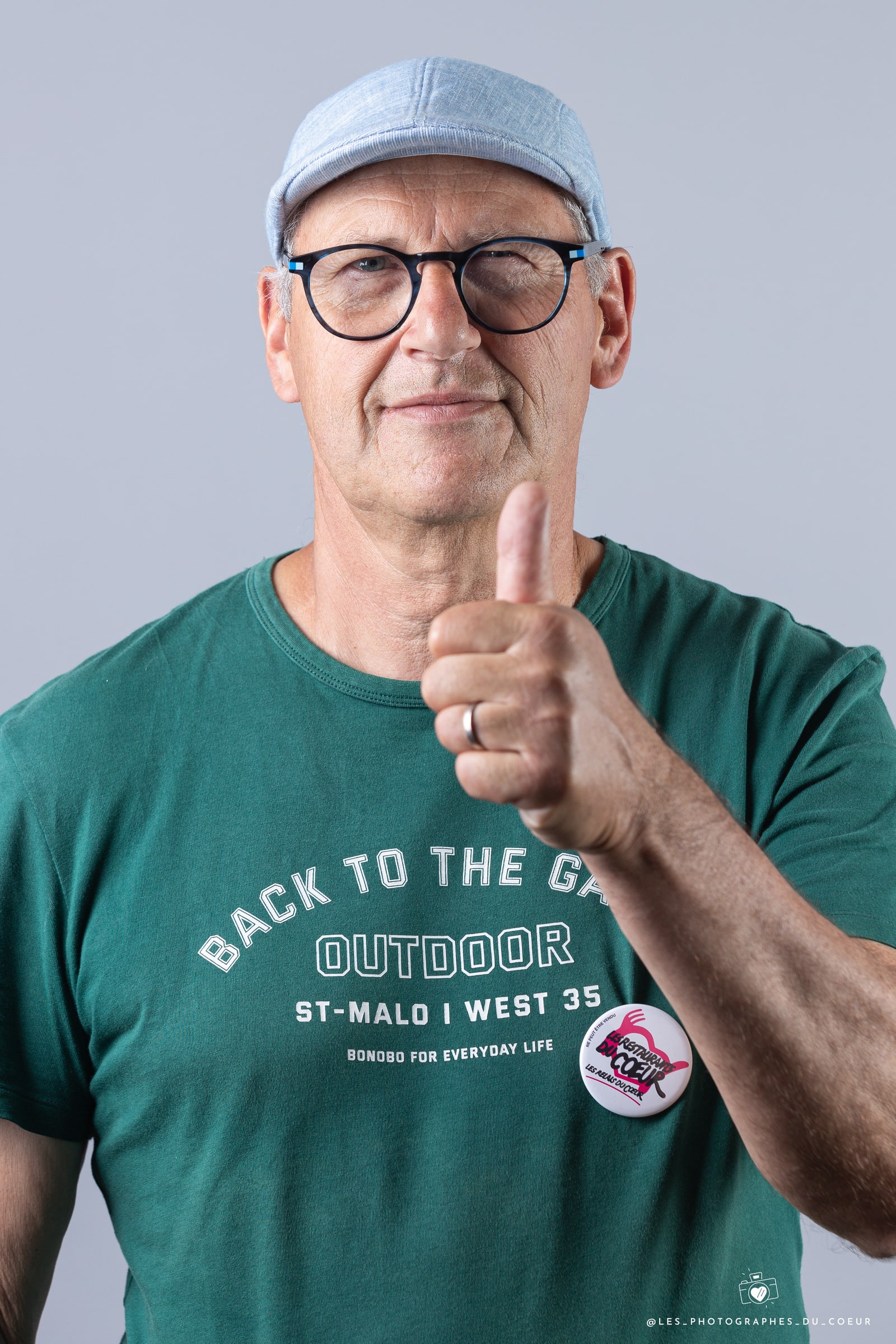 Portrait d’un homme souriant, le pouce levé.